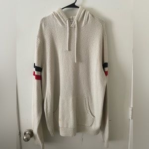 Casual tan hoodie with red and blue sleeve stripes.